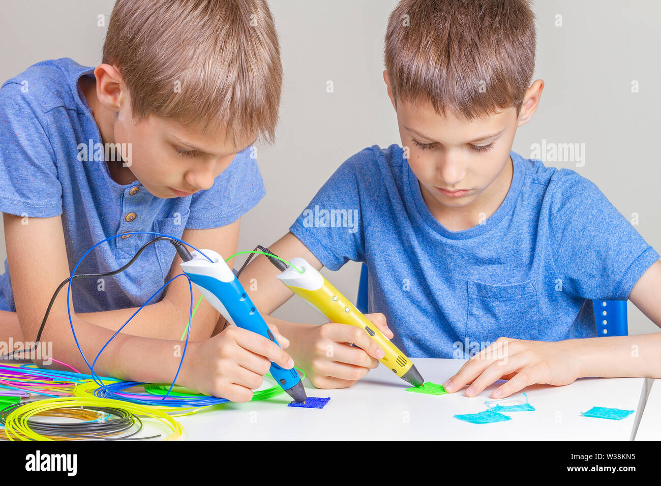 Two boys creating with 3d printing pens Stock Photo - Alamy