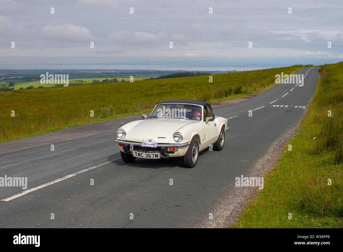 1973 70s white Triumph Spitfire at Scorton, Lancashire.  Sunny conditions as the Lancashire Car Club Rally Coast to Coast crosses the Trough of Bowland. Vintage, classic, collectible, heritage, historics vehicles left Morecambe heading for a cross county journey over the Lancashire landscape to Whitby. Stock Photo
