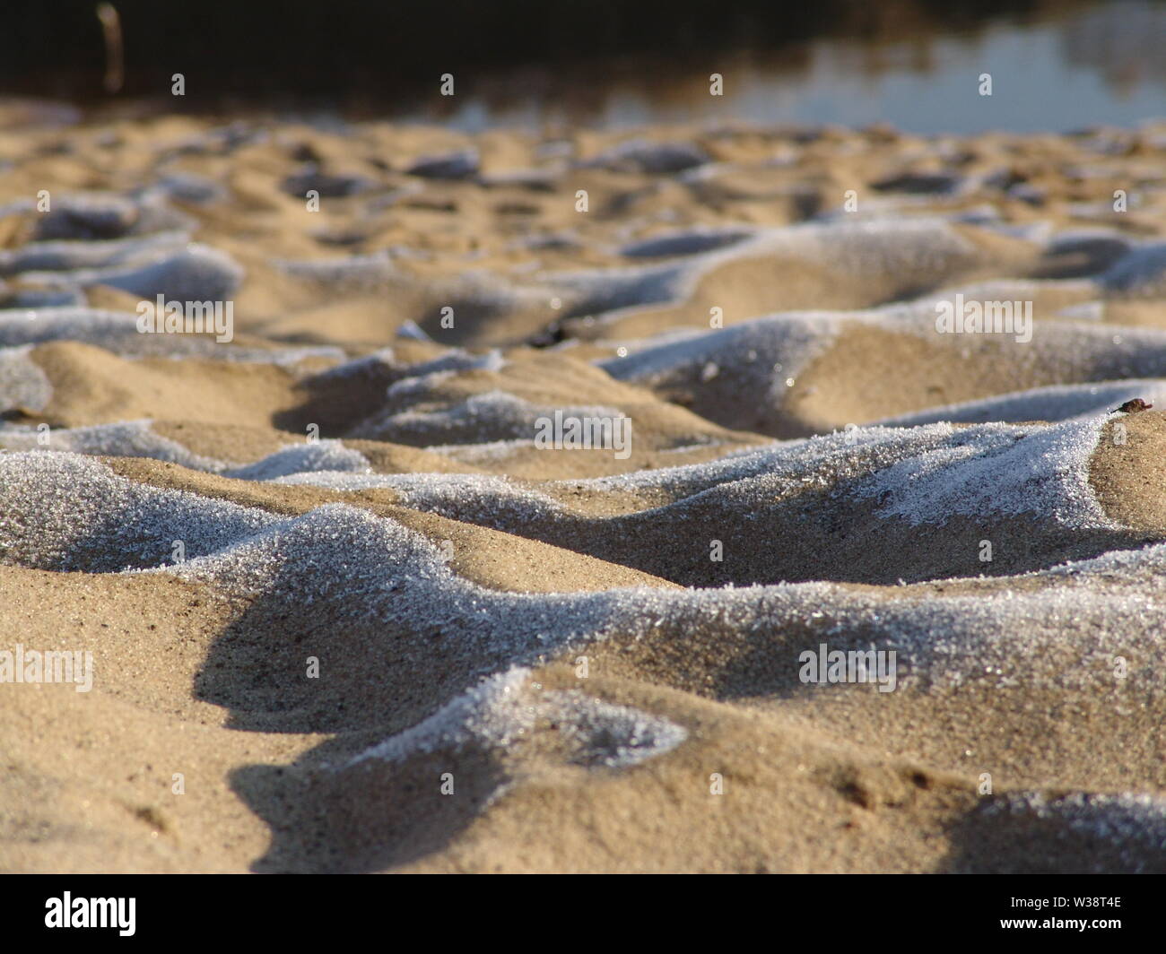 Sand in the hoarfrost on the river bank Stock Photo
