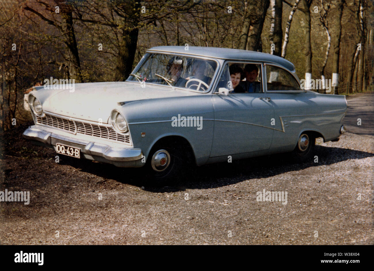 1960, historical, people sitting in a Ford Taunus P2 (17M) motor car parked beside some woodland. Similar to the UK's Ford Cortina. the Taunus was made by Ford Germany and sold throughout Europe. The stylish  car was named after the Taunus mountain range in Germany and was the second newly-designed German Ford to be launched after the war. Stock Photo
