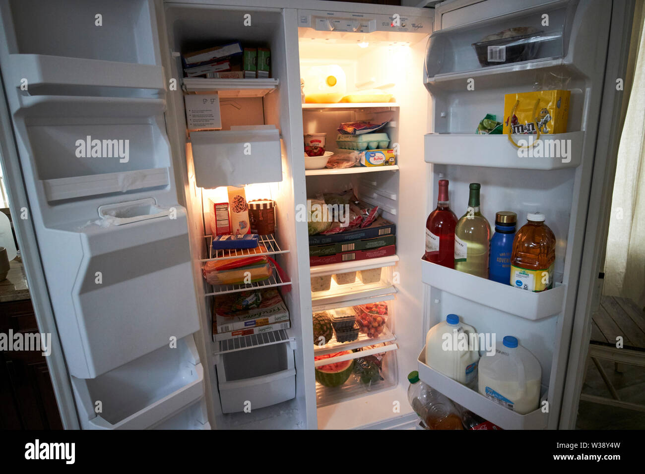 doors open of a well stocked large us kitchen fridge freezer USA United States of America Stock Photo