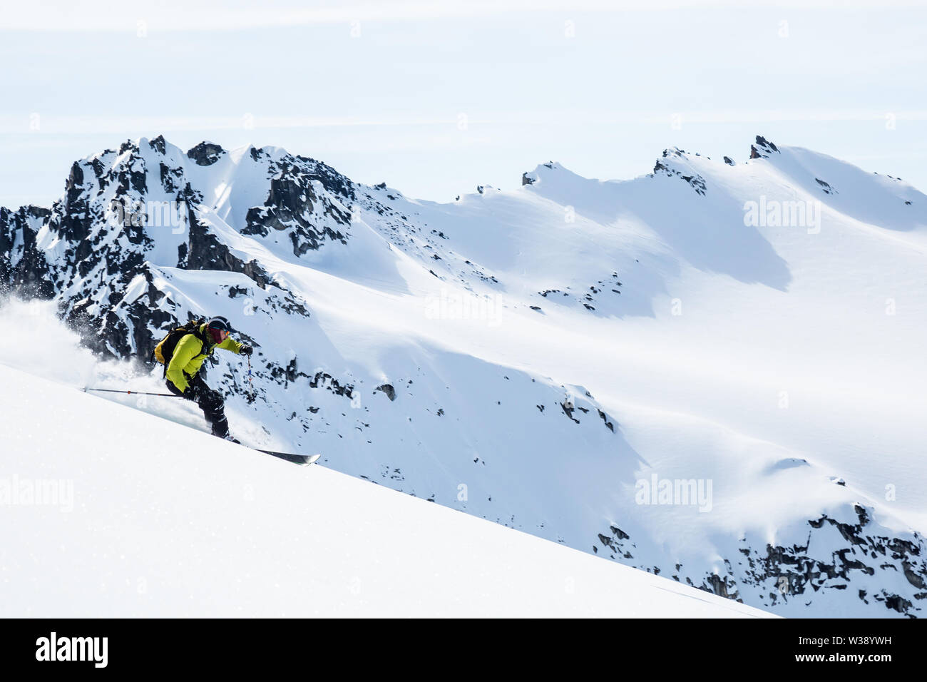 Backcountry skier on remote Alaskan peaks in the Talkeetna Mountains. Large, snowy peaks in the Stock Photo