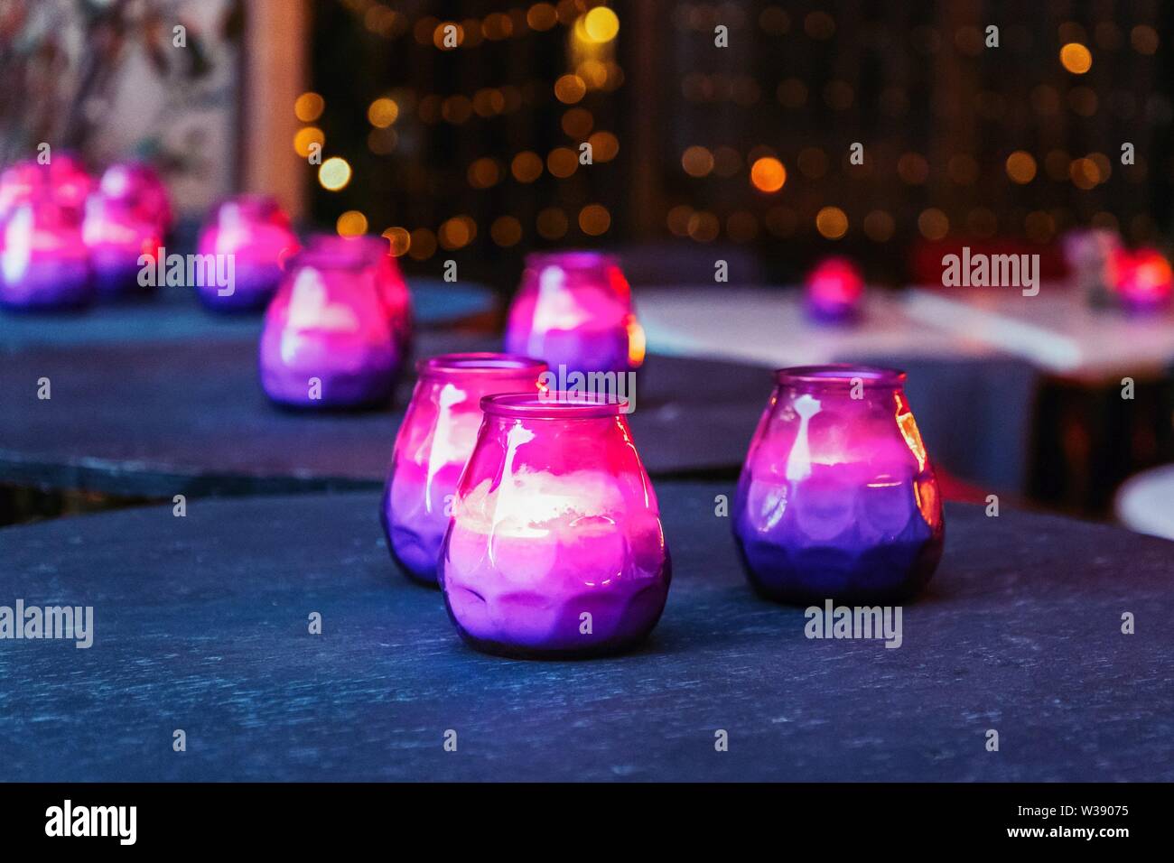 Burning purple and pink candles on the table. Hygge concept Stock Photo