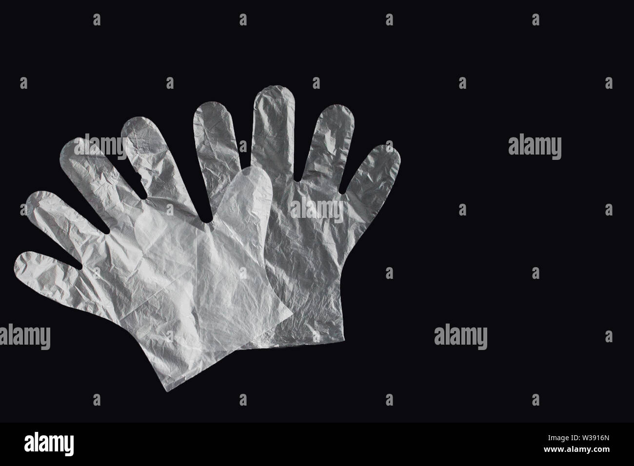 Plastic bag with handles, gloves, on a black background . Used plastic bag  for recycling. Concept - ecology, planet pollution with plastic cellophane  Stock Photo - Alamy