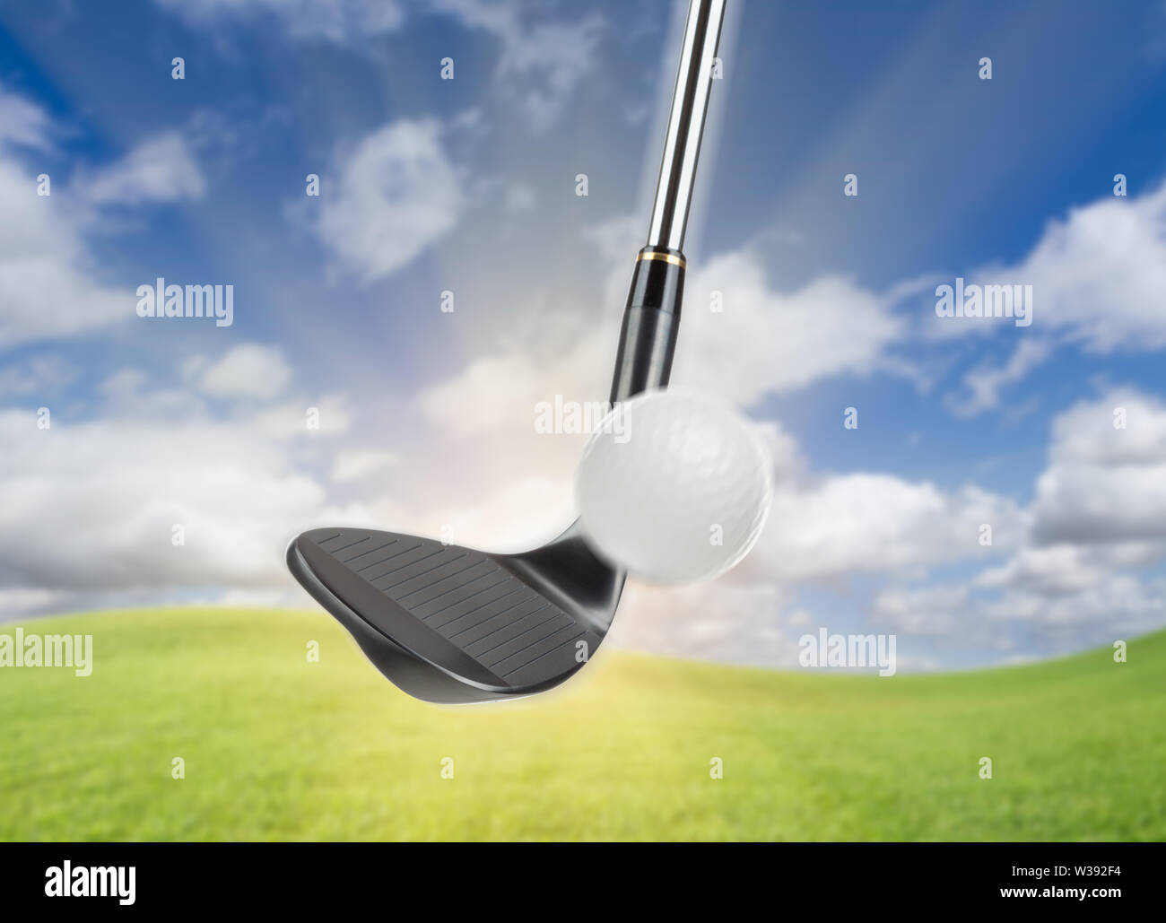 Black Golf Club Wedge Iron Hitting Golf Ball Against Grass and Blue Sky  Background Stock Photo - Alamy