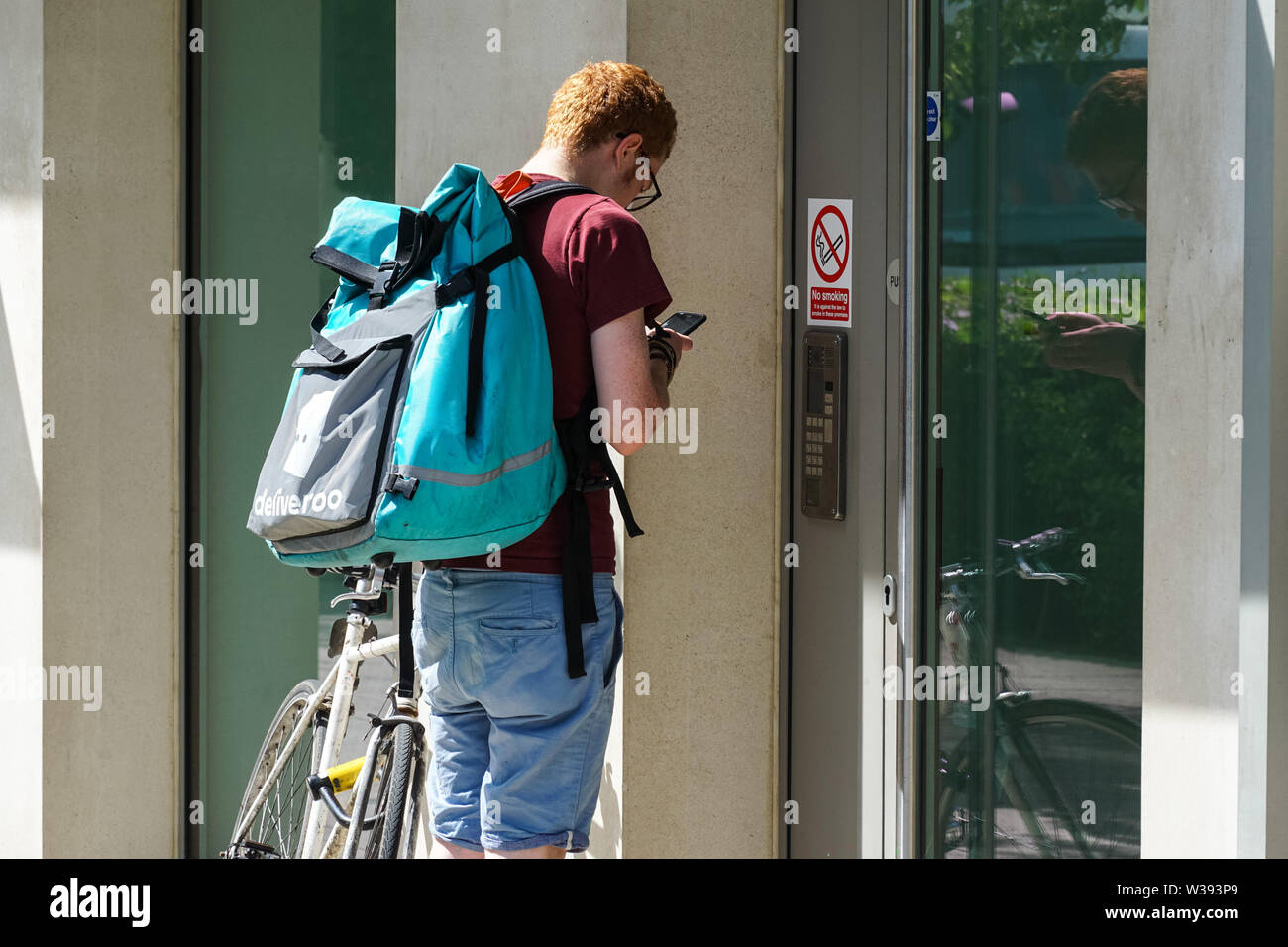 Deliveroo delivery man at the door, London England United Kingdom UK Stock Photo