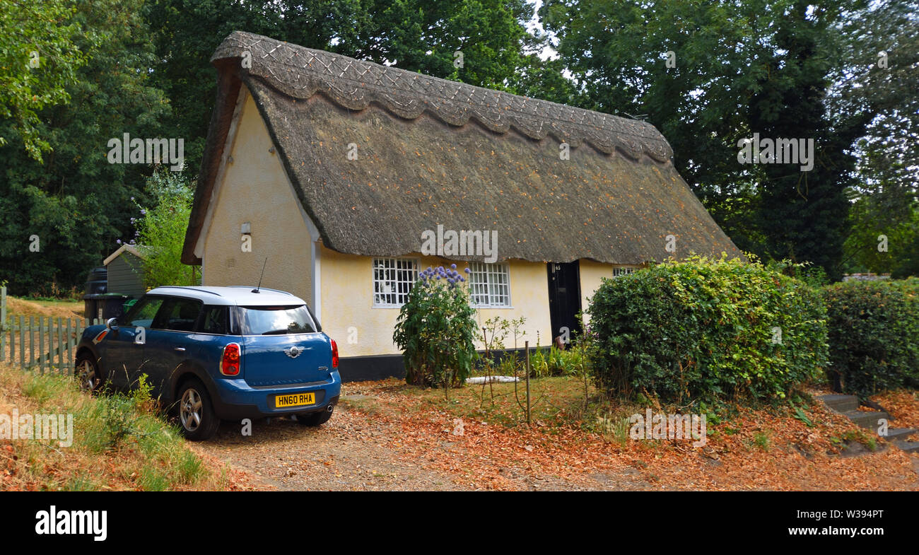 Traditional Thatched Cottage with Mini Motor Car Parked Outside Stock Photo