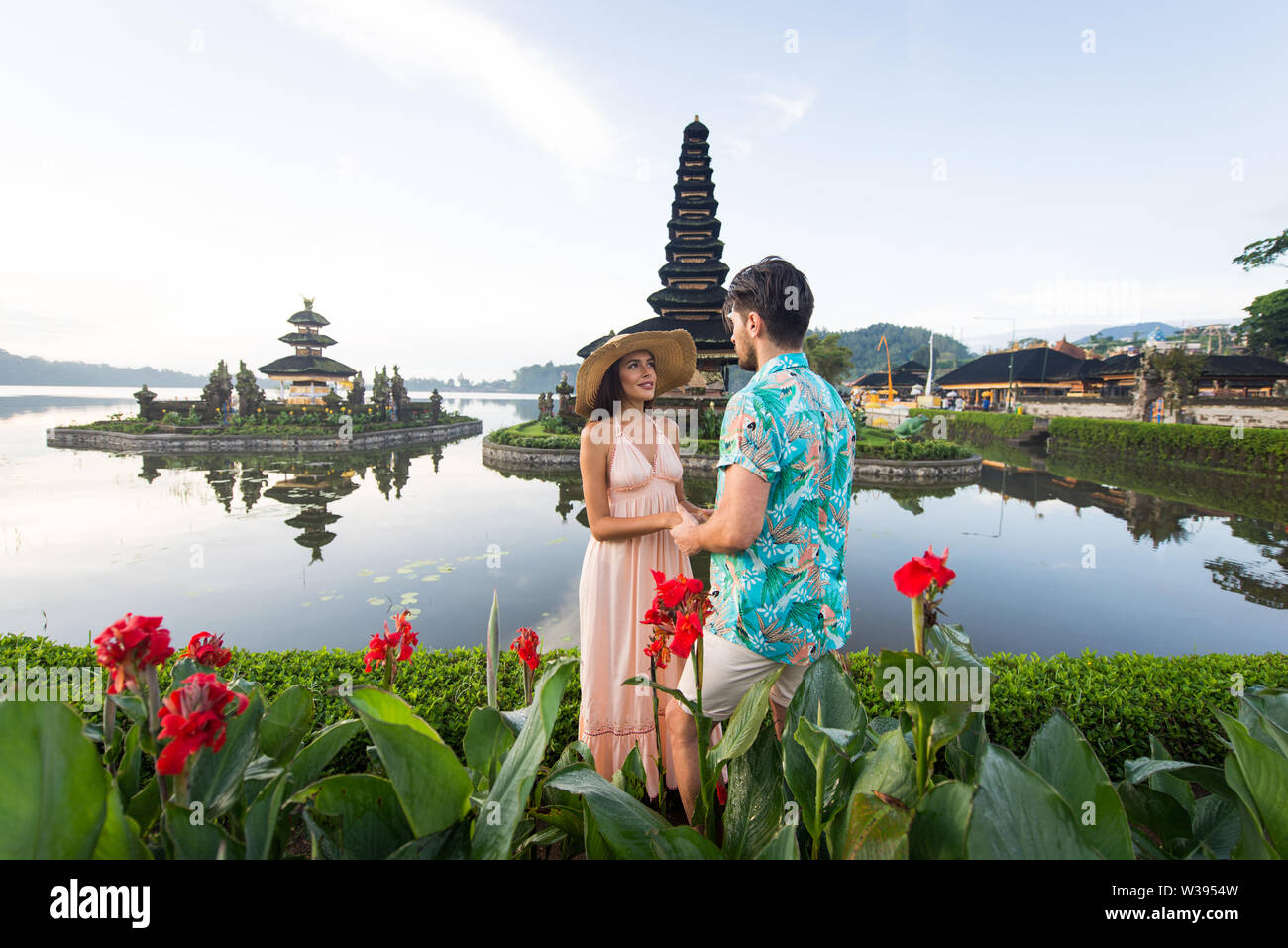 Couple at the Pura Ulun Danu Bratan, Bali. Hindu temple surrounded by flowers on Bratan lake, Bali. Stock Photo