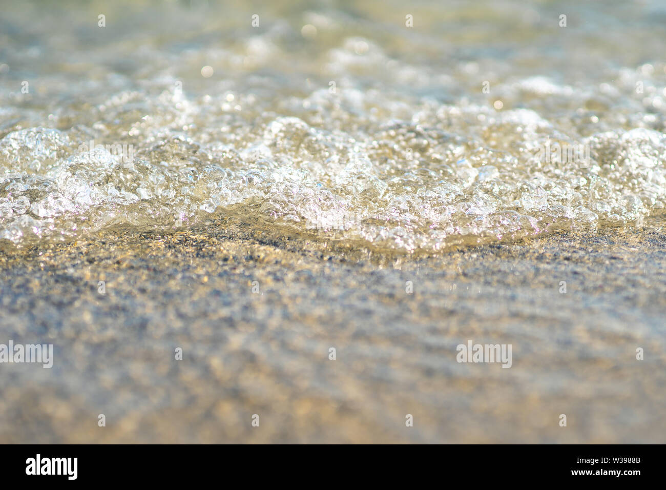 close up of a wave rolling onto the beach in Crete Stock Photo