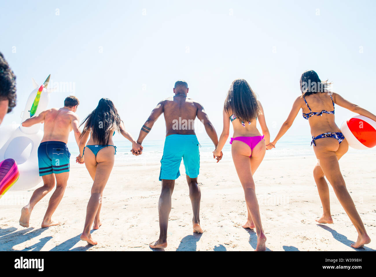 Group of friends having fun on the beach - Young and happy tourists bonding outdoors, enjoying summertime Stock Photo