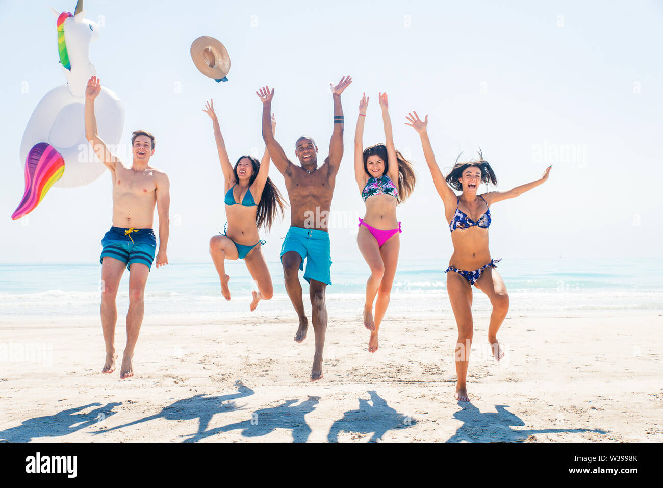 Group of friends having fun on the beach - Young and happy tourists bonding outdoors, enjoying summertime Stock Photo