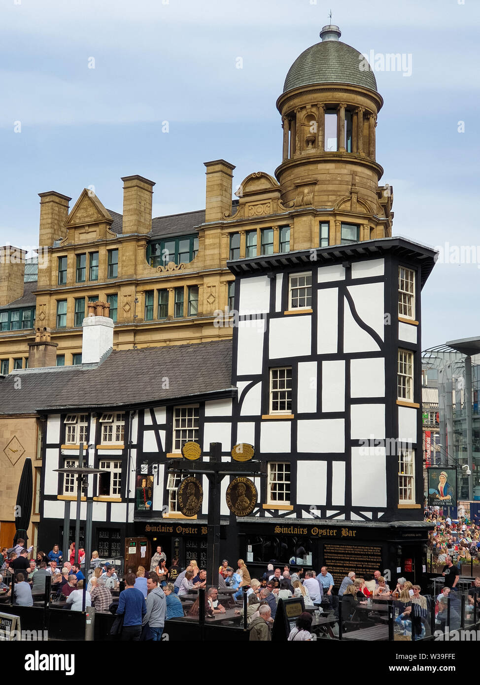 Manchester, United Kingdom - April 23, 2019: People enjoy themselves seated outsideat a pub in Manchster city centre on a beautuful spring afternoon Stock Photo