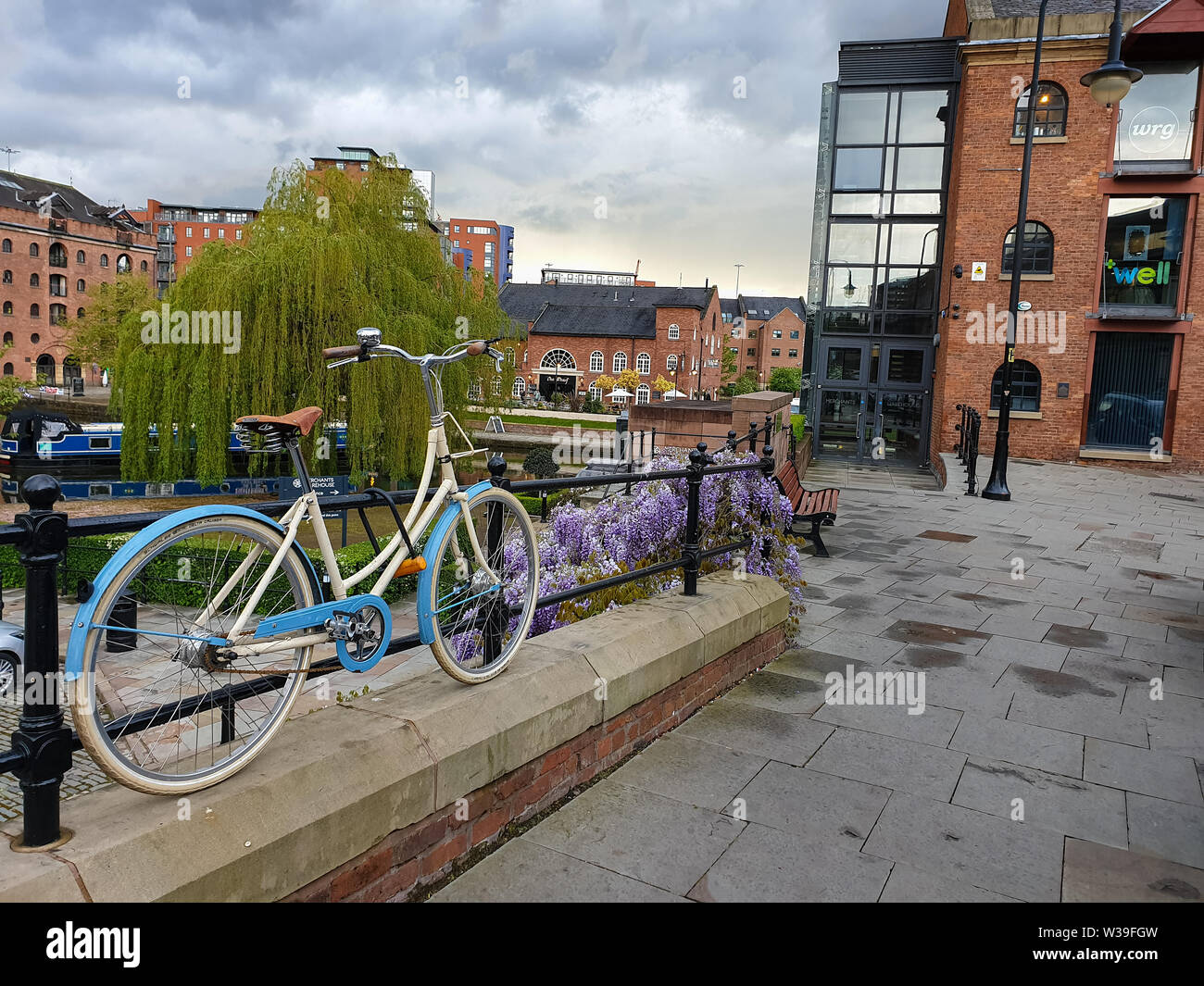 Manchester, United Kingdom - April 25, 2019: Atmospheric scene of a parked bicycle at the restored Victorian canal system in Castlefield area of Manc Stock Photo