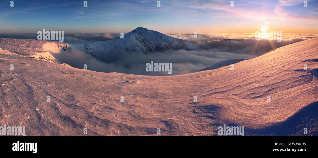 Sunrise view of Pec pod Snezkou in the Krkonose Mountains  in winter. Czech Republic. Morning panoramic view from footpath to the peak of Snezka Mount Stock Photo