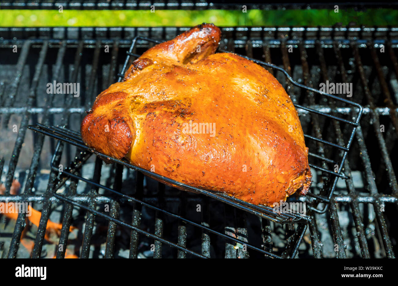 Roast of delicious roasted chicken on flaming charcoal grill Stock