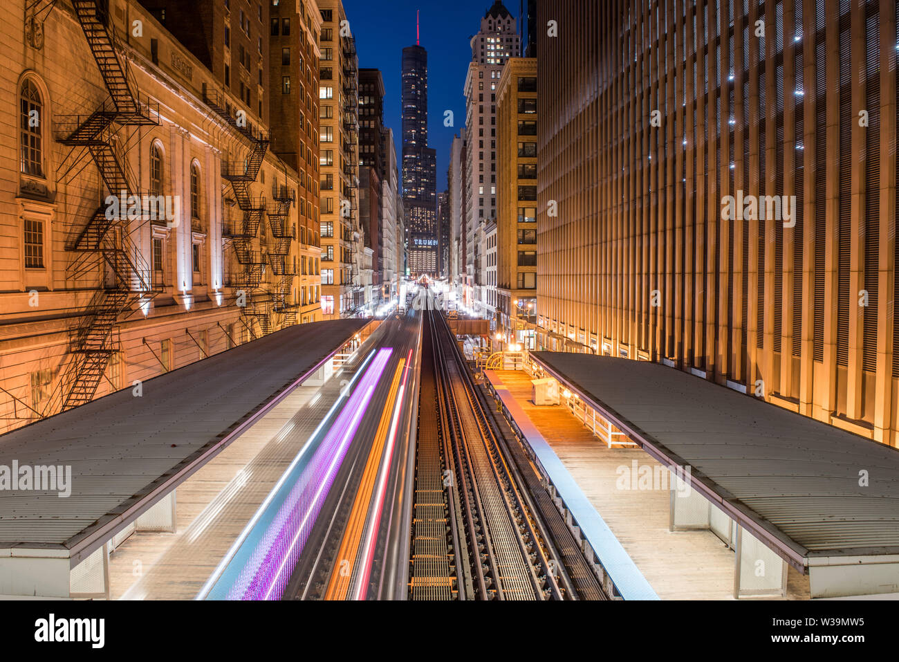 view of Chicago EL train light trails and trump tower from adams/Wabash station at blue hour Stock Photo