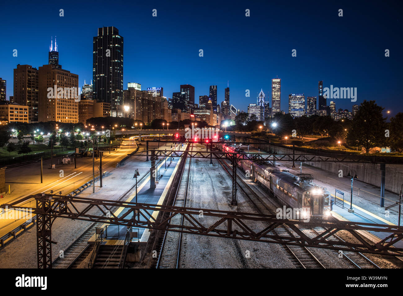 View of Central station , el train light trails and downtown Chicago city skyline at blue hour Stock Photo