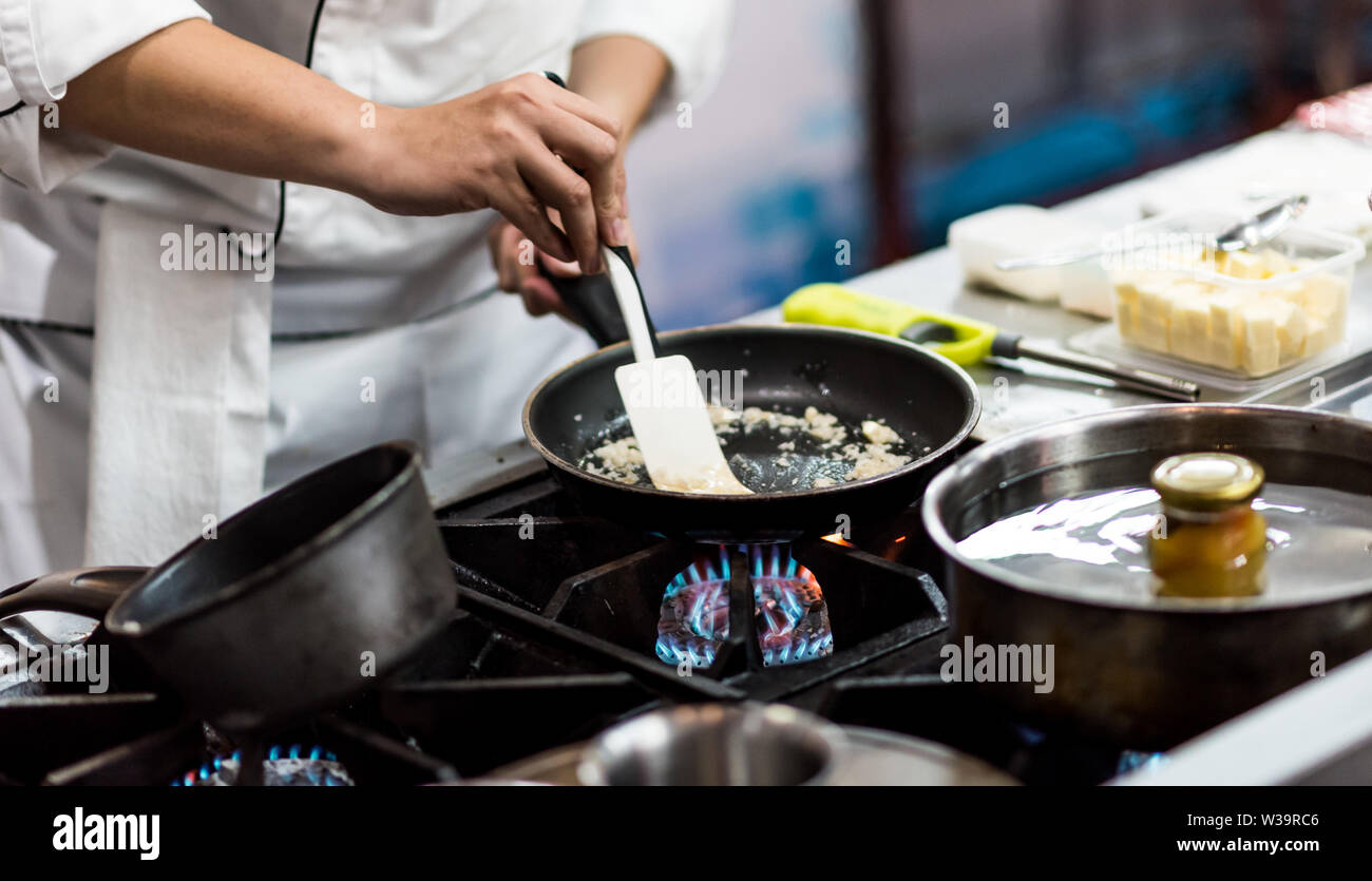 Chef cooking food in the kitchen, Chef preparing food Stock Photo - Alamy
