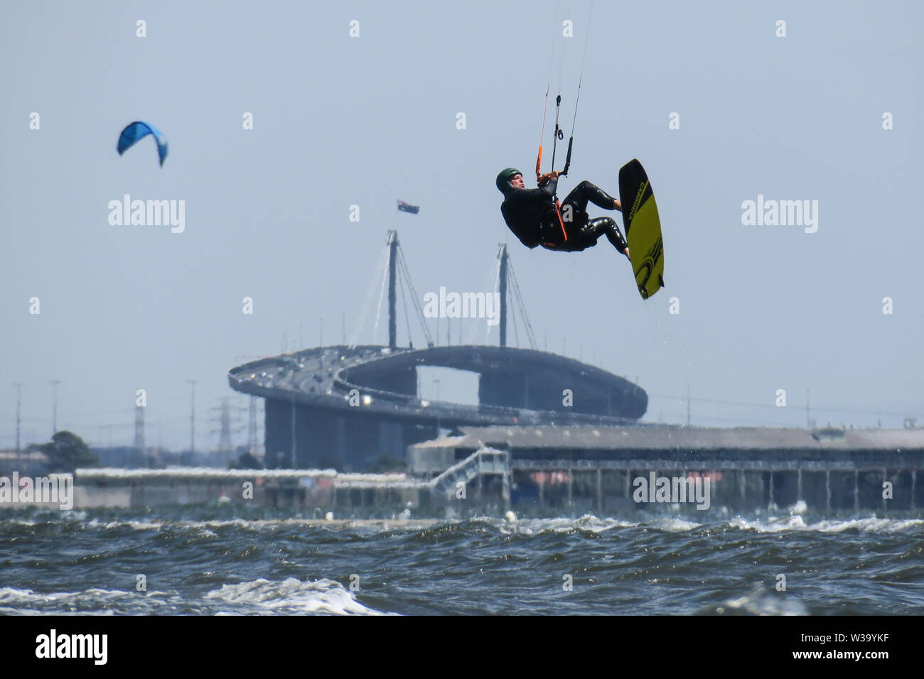 Kitesurfing on a windy day at Port Phillip Bay Melbourne Australia with West Gate Bridge in the background. Stock Photo