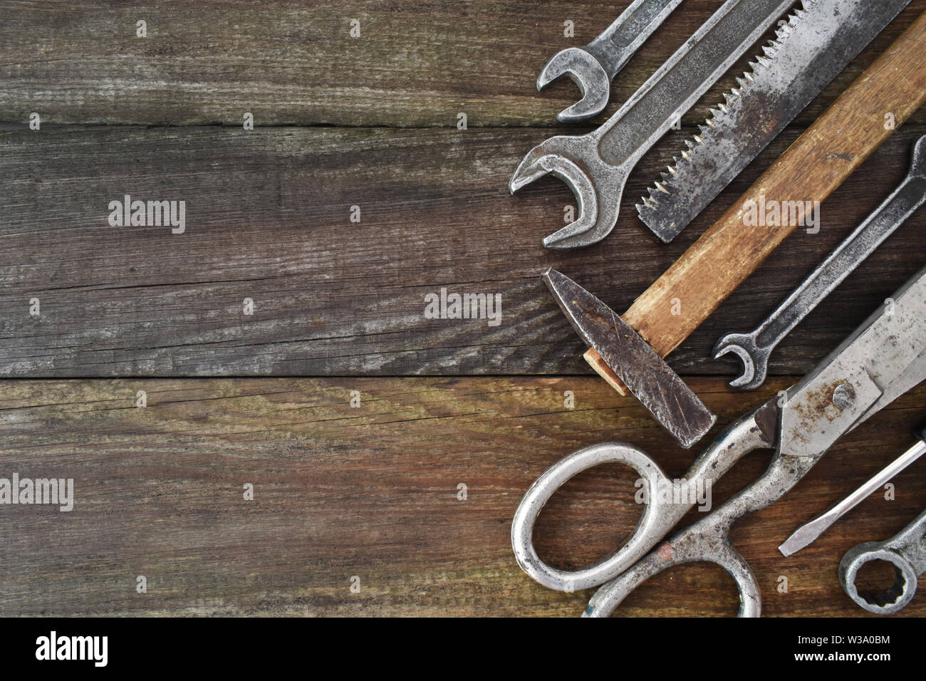Retro vintage woodwork equipment set. Hammer scissors screwdriver on brown texture wooden planks background. Old carpentry rusty tools handy craft Stock Photo