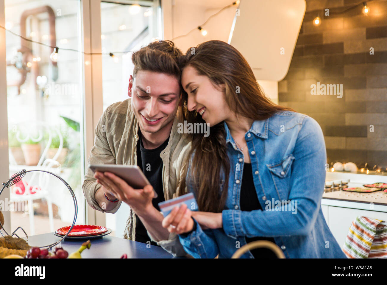 Beautiful young couple of lovers shopping online on a computer tablet ...