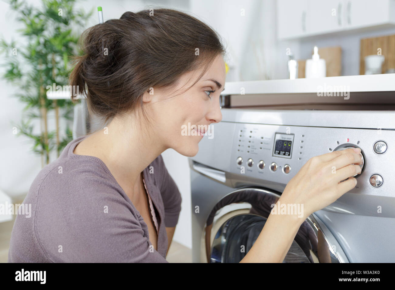 woman after loading dirty clothes in washing machine Stock Photo Alamy