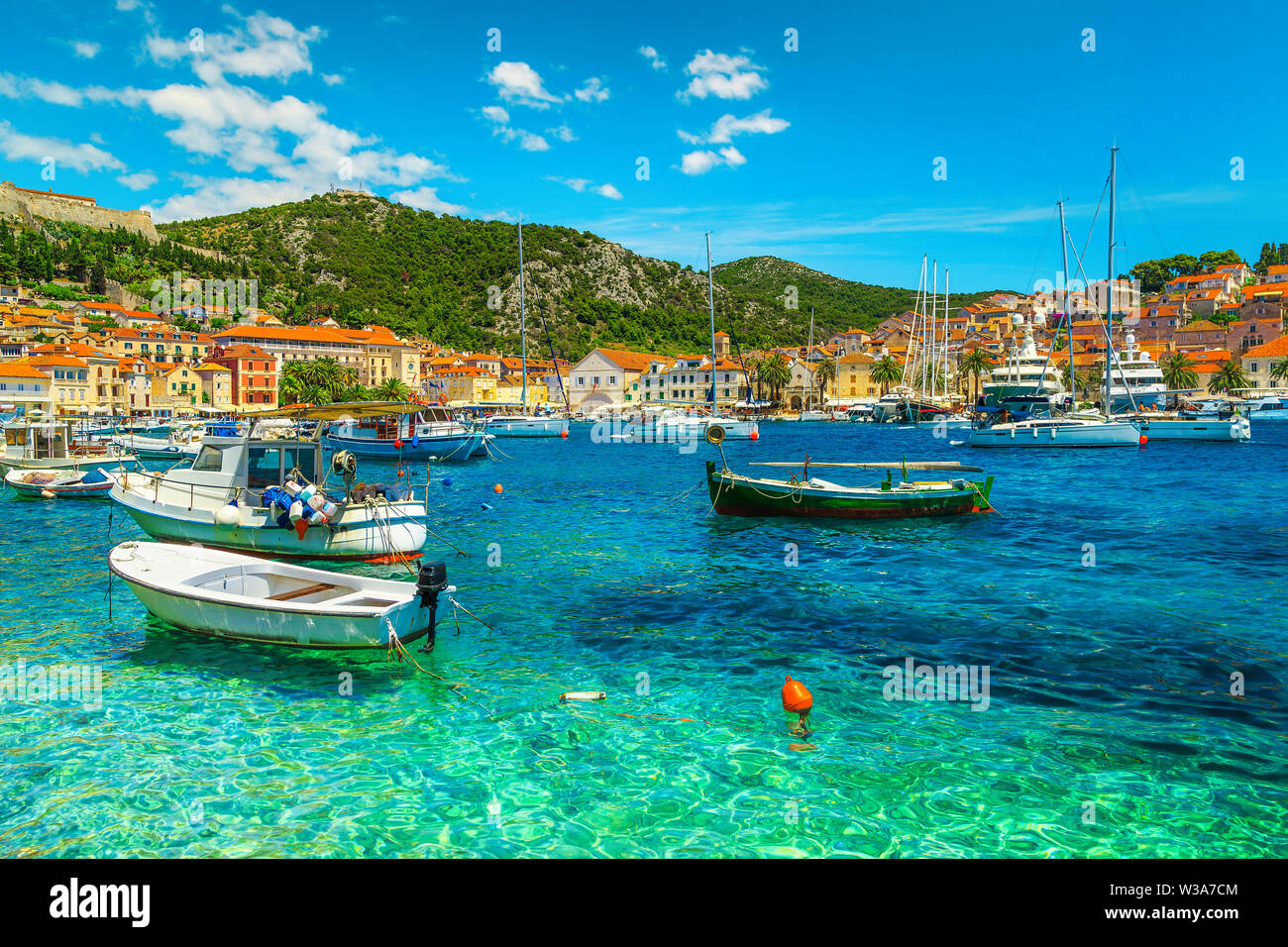Popular travel and beach vacation destination. Well known medieval historic town with luxury yachts, sailing boats and fishing boats, Hvar town, Hvar Stock Photo