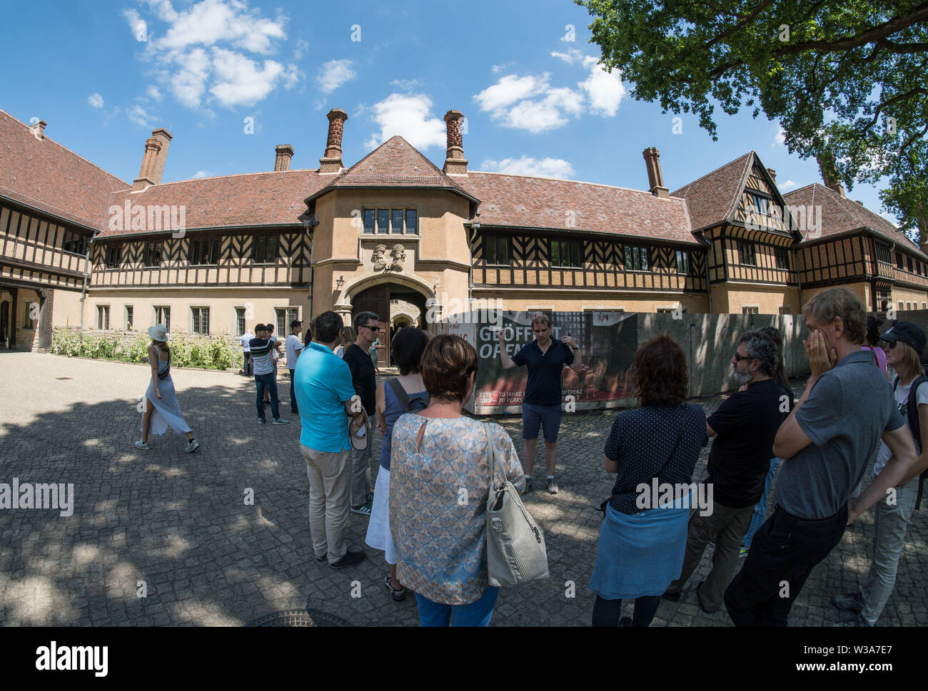Potsdam, Germany. 15th July, 2018. A group of visitors stands at the entrance to Cecilienhof Castle. Cecilienhof was built between 1913 and 1917 by Emperor Wilhelm II for his son Crown Prince Wilhelm. Here, after the Second World War, the Allies signed the Potsdam Agreement. Credit: Frank Rumpenhorst/dpa/Alamy Live News Stock Photo