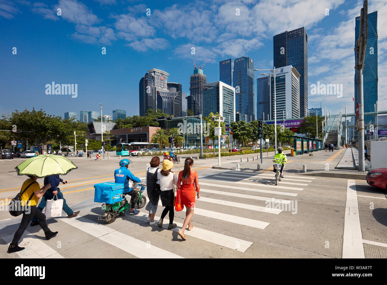 Pedestrians crossing street in Futian Central Business District (CBD). Shenzhen, Guangdong Province, China. Stock Photo