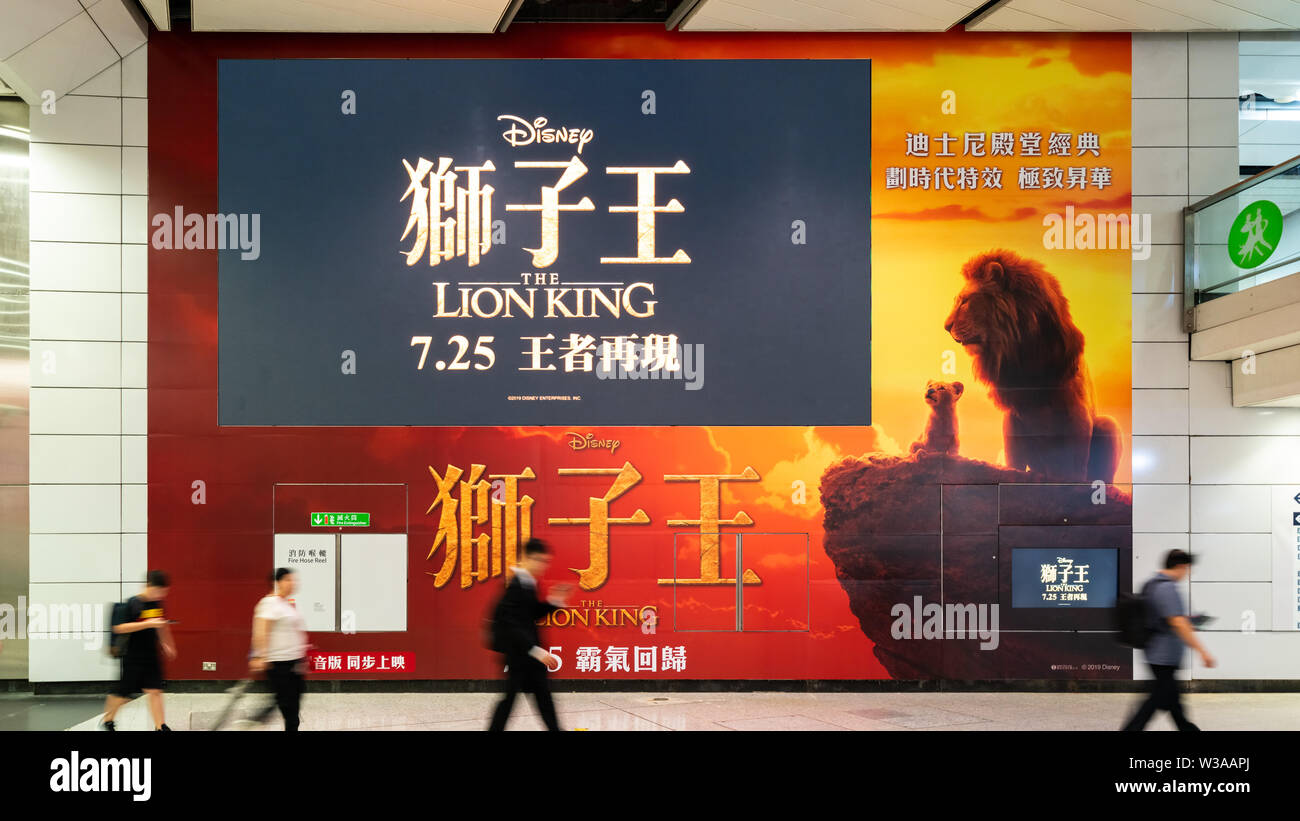 Hong Kong, Hong Kong - Jul 10, 2019: Lion King big movie poster and large TV screen showing movie trailer in public subway walkway. Cinema promotional Stock Photo