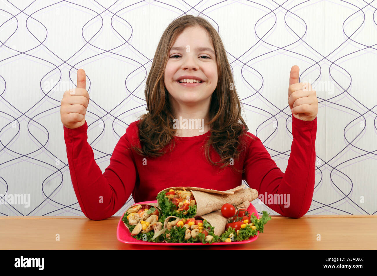 happy little girl with burritos mexican food and thumbs up Stock Photo