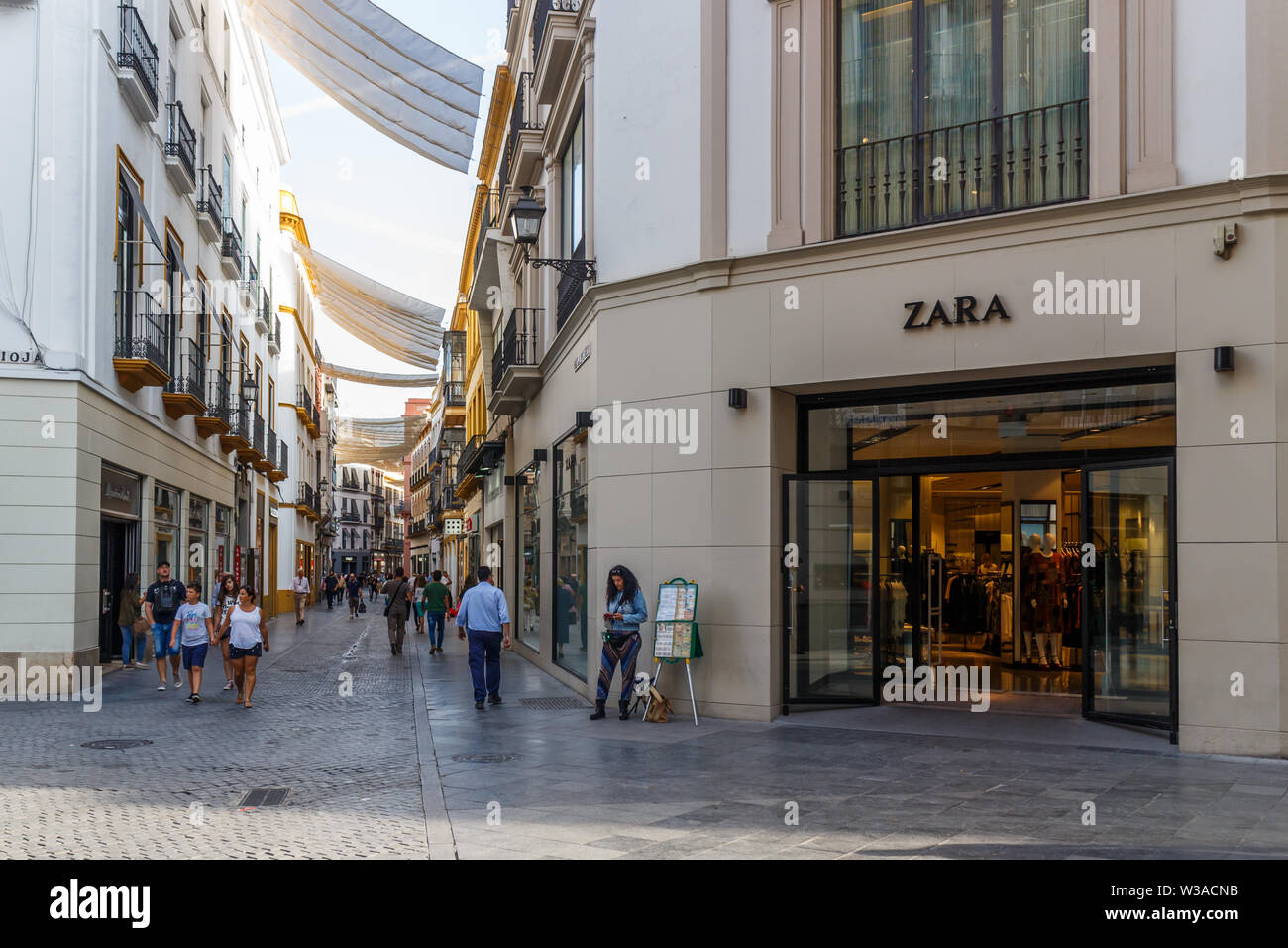 Seville, Spain - September 3rd 2015: Shopping street with a Zara store. Zara  is the main brand of the Inditex group Stock Photo - Alamy