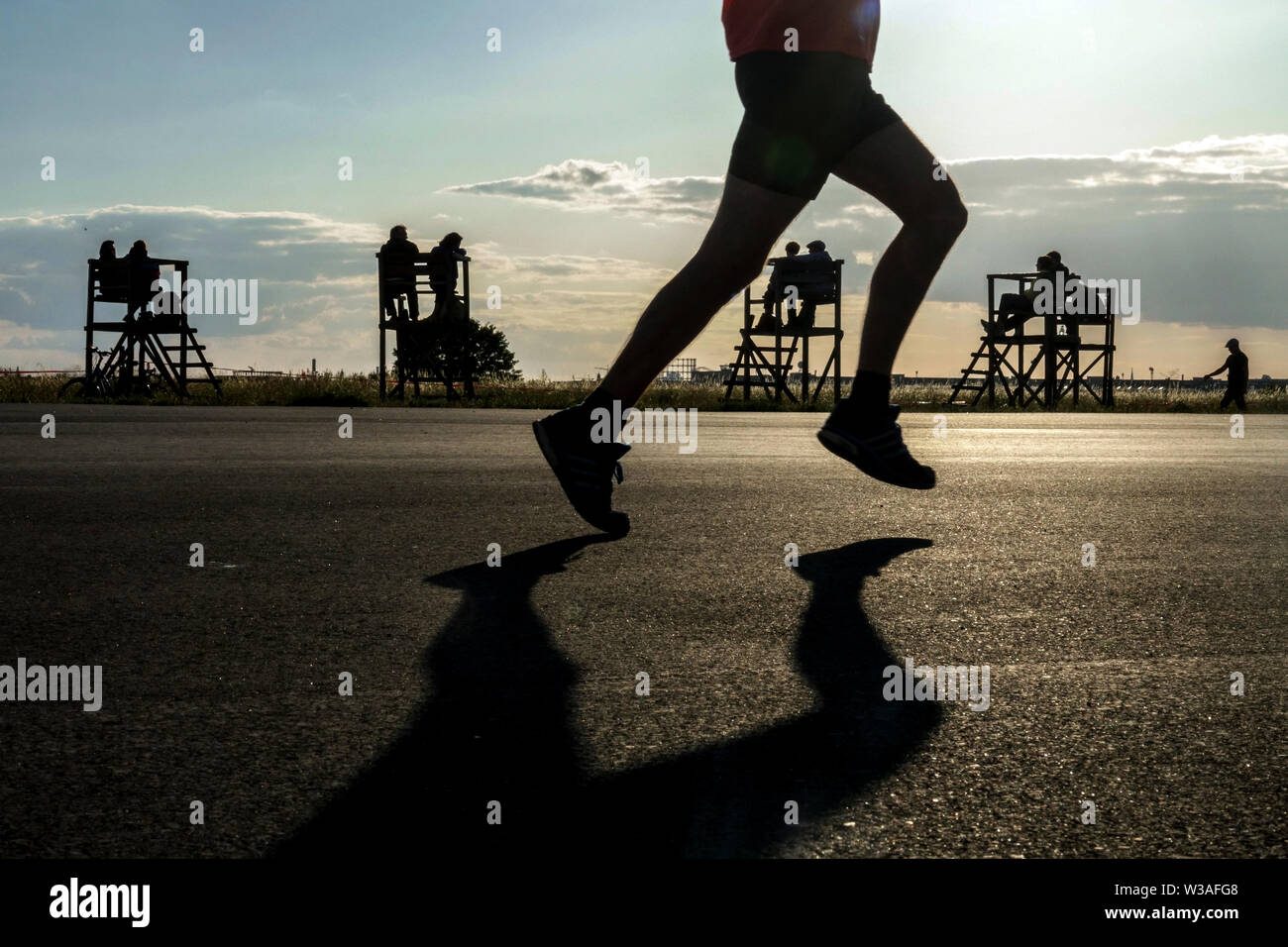 Berlin Tempelhof airfield Silhouette of people and a runner Germany running Stock Photo