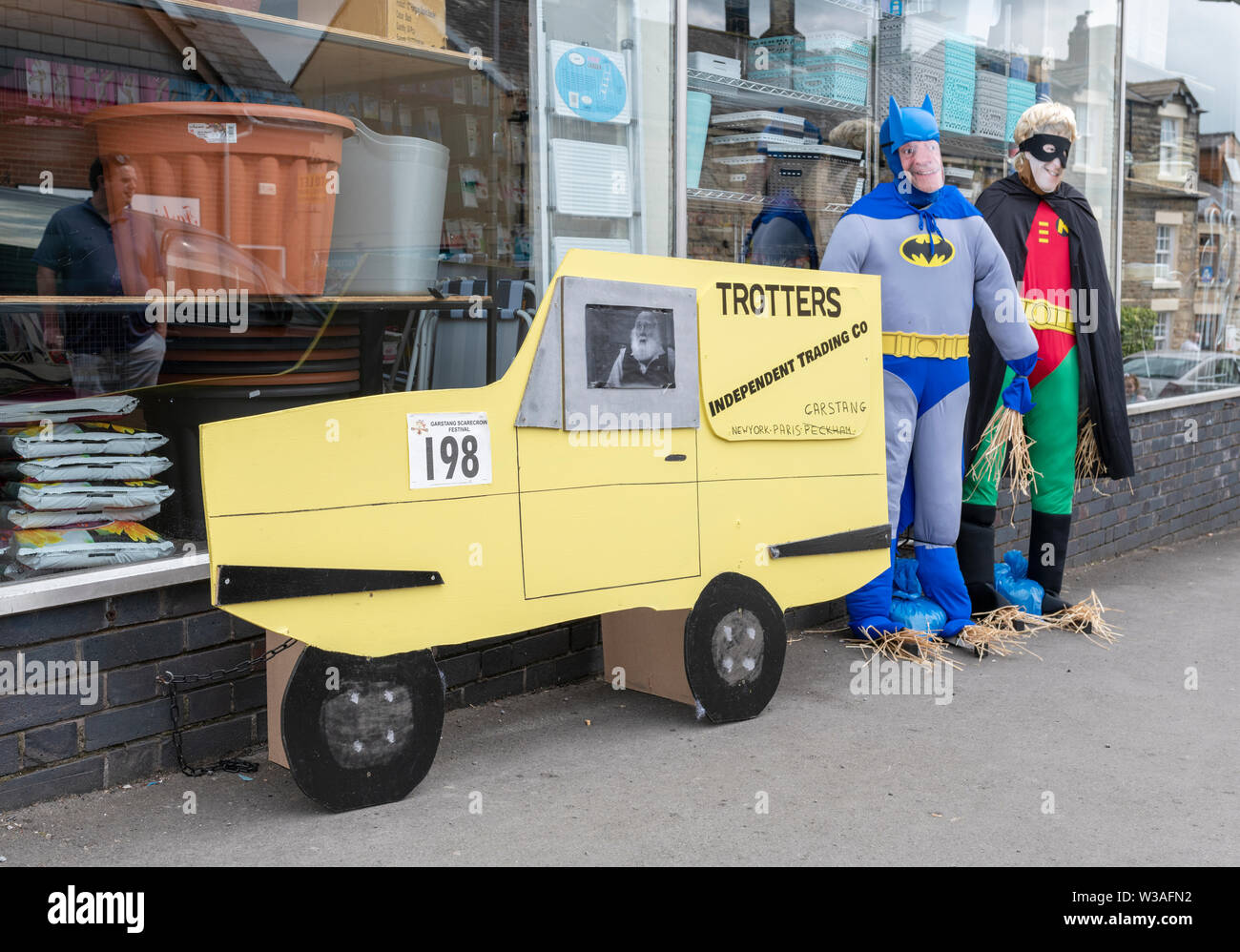 An exhibit at the Garstang Scarecrow Festival. Del and Rodney from Only Fools and Horses, dressed as Batman and Robin with their yellow three wheeler Stock Photo