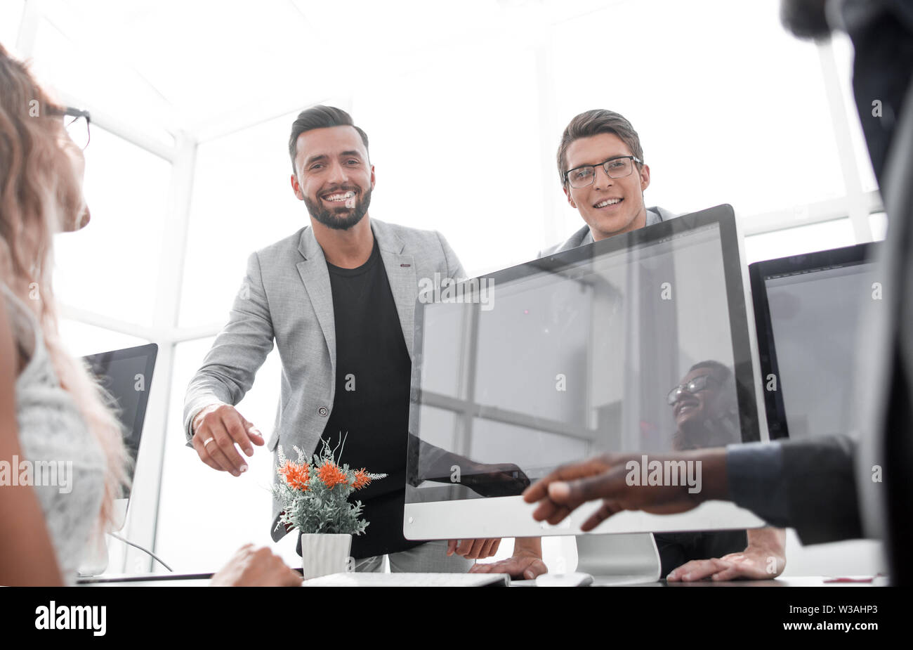 young employees giving each other high five Stock Photo