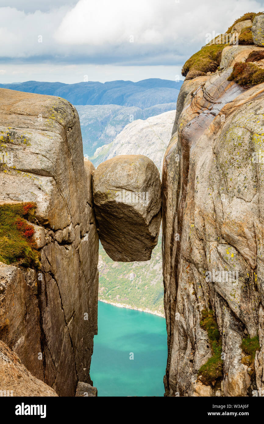 Kjeragbolten, the stone stuck between two rocks with fjord in the background, Lysefjord, Norway Stock Photo