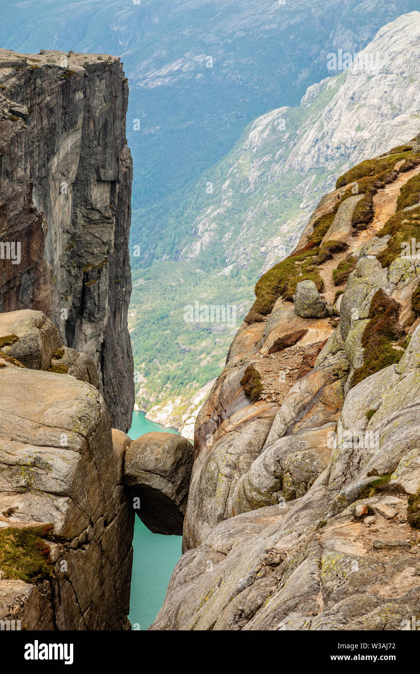 Kjeragbolten, view from the top to the stone stuck between two rocks with fjord in the background, Lysefjord, Norway Stock Photo
