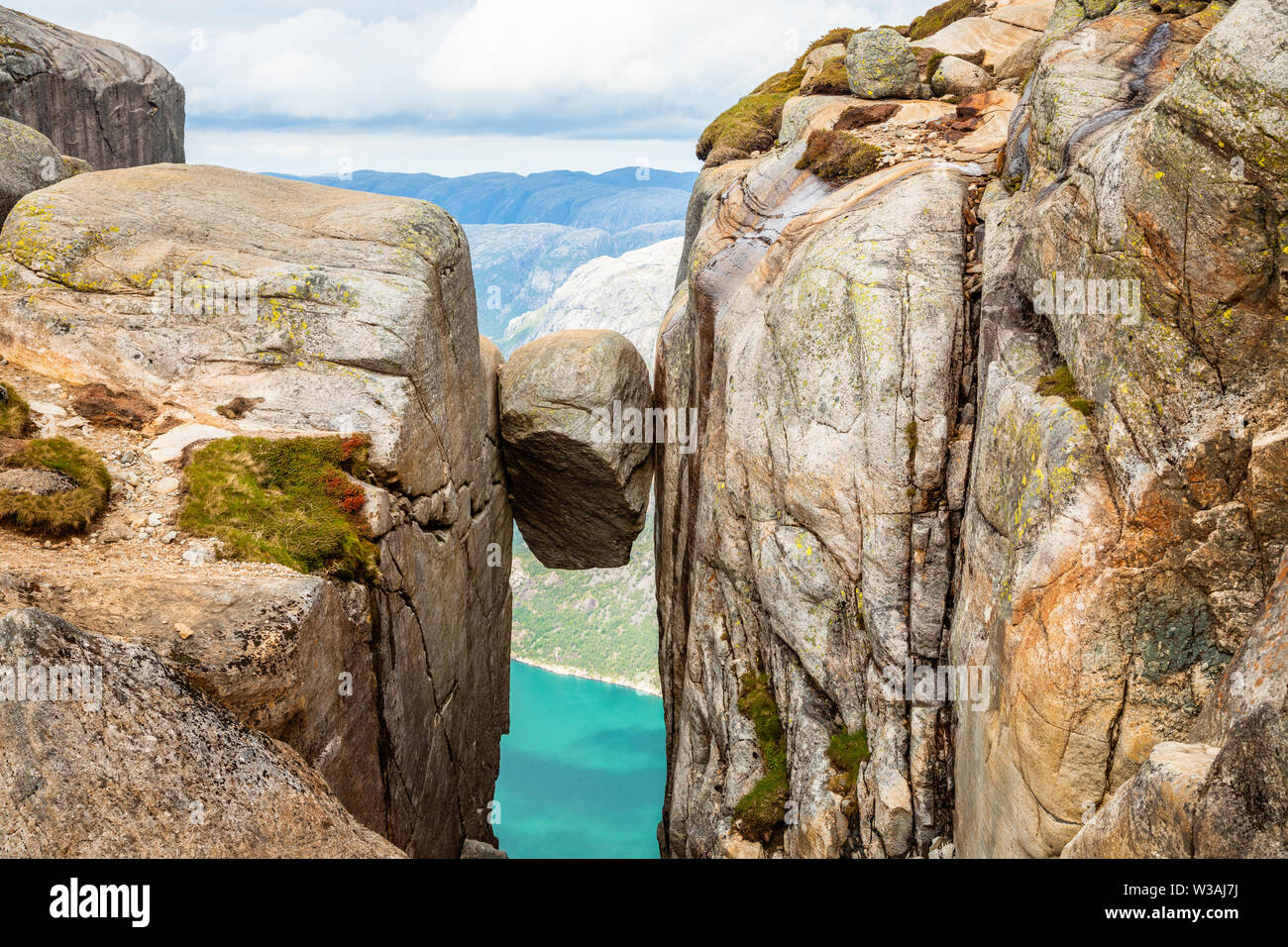 Kjeragbolten, the stone stuck between two rocks with fjord in the background, Lysefjord, Norway Stock Photo