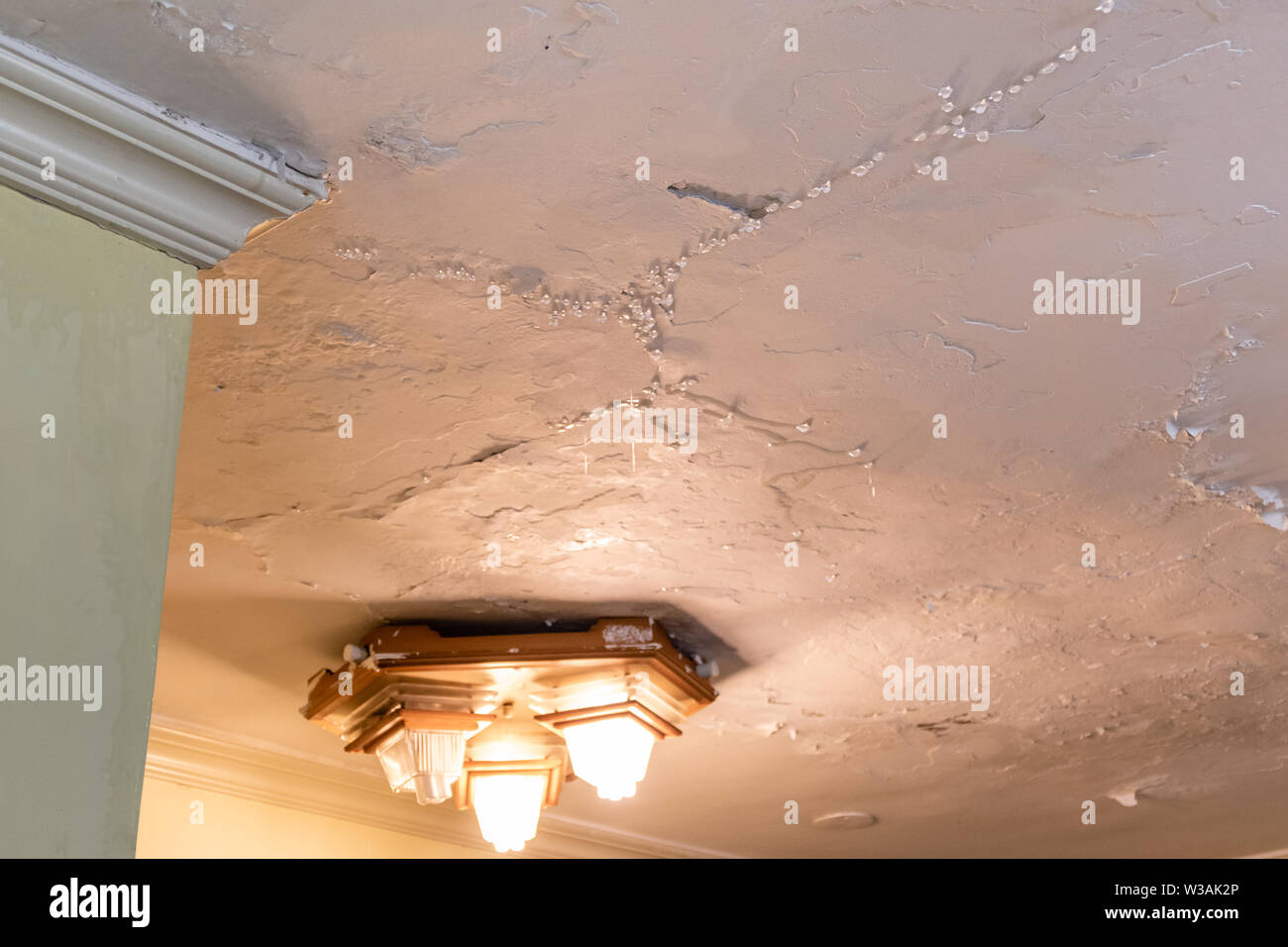 Water dripping from leaking ceiling, water damge concept Stock Photo
