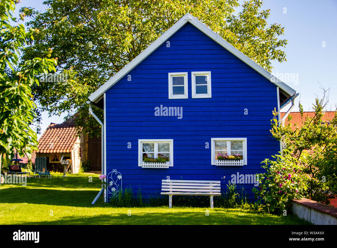 Unidentified big blue, generic painted garden house in the Scandinavian building style made out of wood Stock Photo
