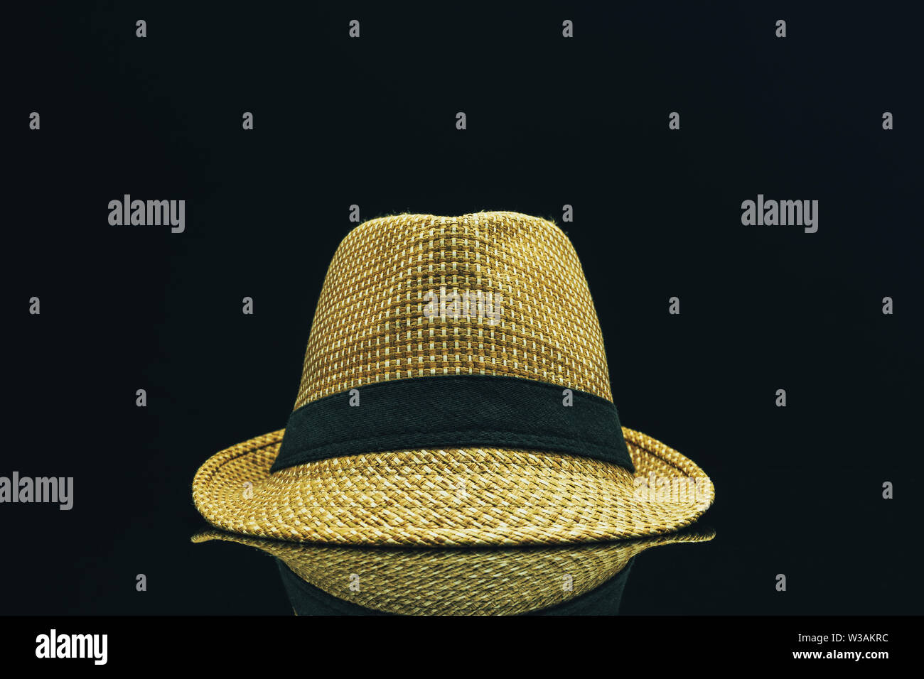 https://c8.alamy.com/comp/W3AKRC/straw-hat-on-a-black-glass-table-background-W3AKRC.jpg