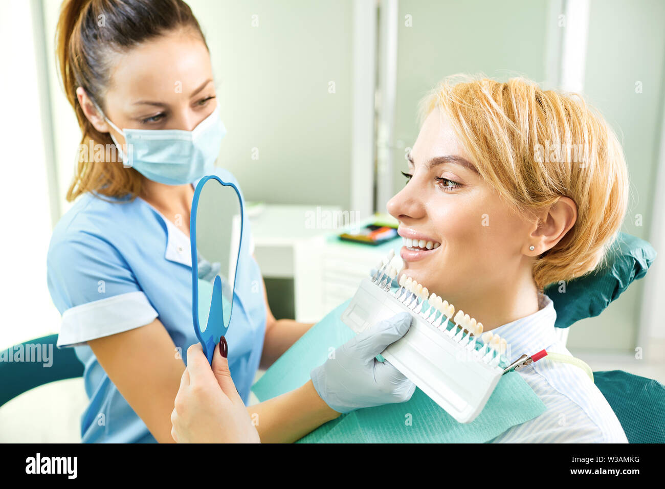 Teeth whitening dental clinic. Dentist selects the shade of the teeth