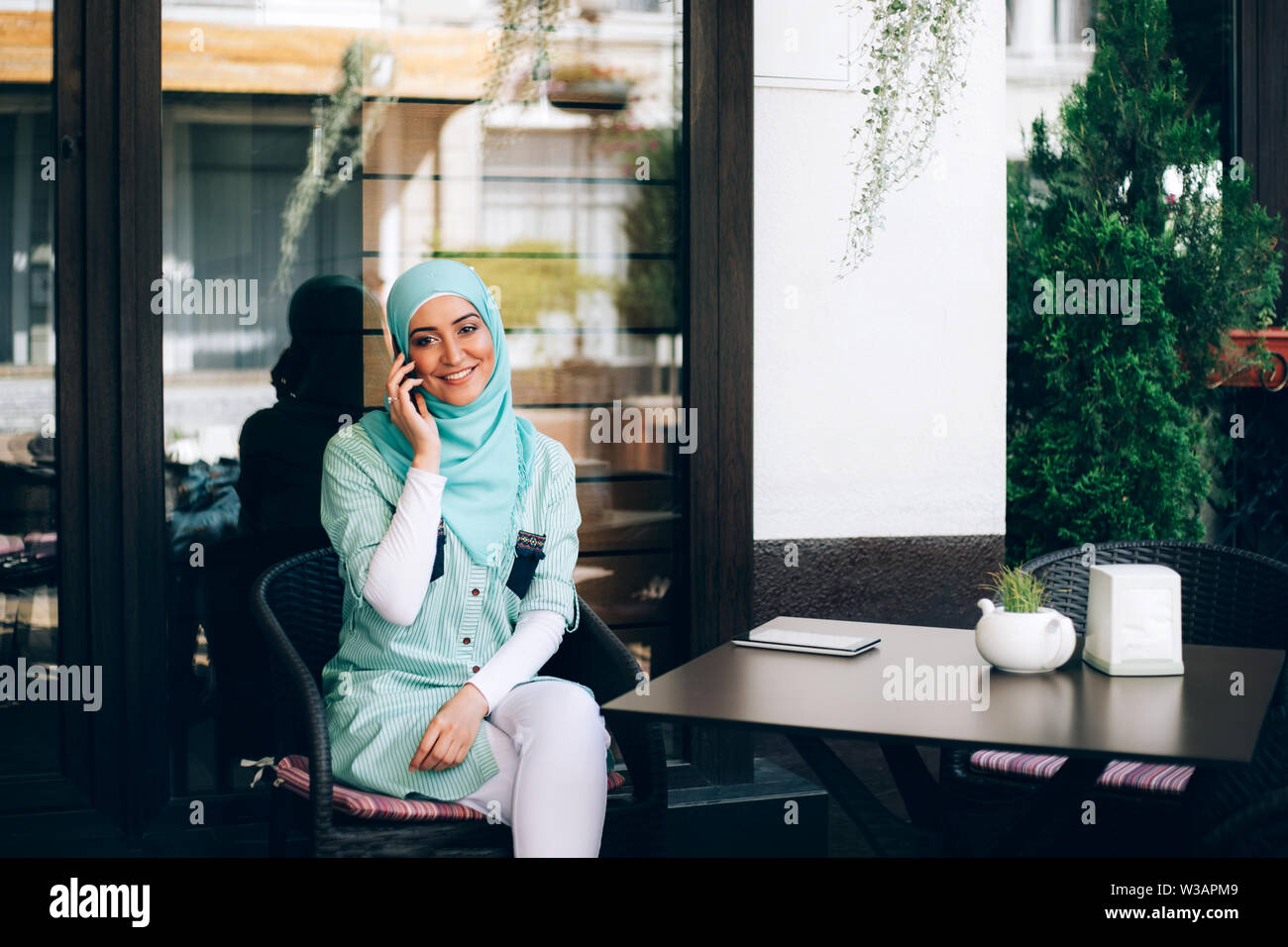 Beautiful young arabic girl in hijab talking by phone at cafe Stock ...