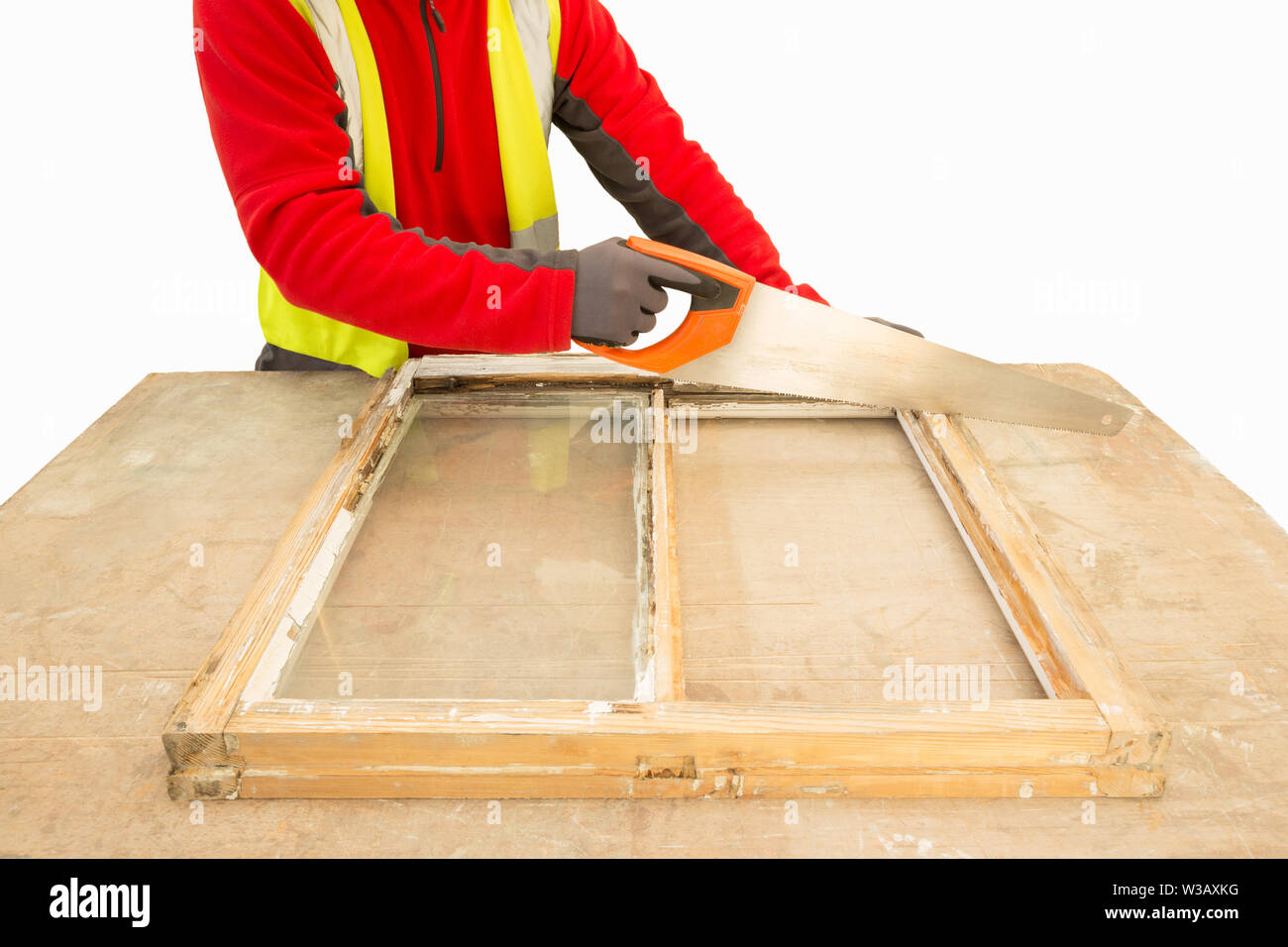 Carpenter using a handsaw while repairing and restoring an old window frame sash. Sash window