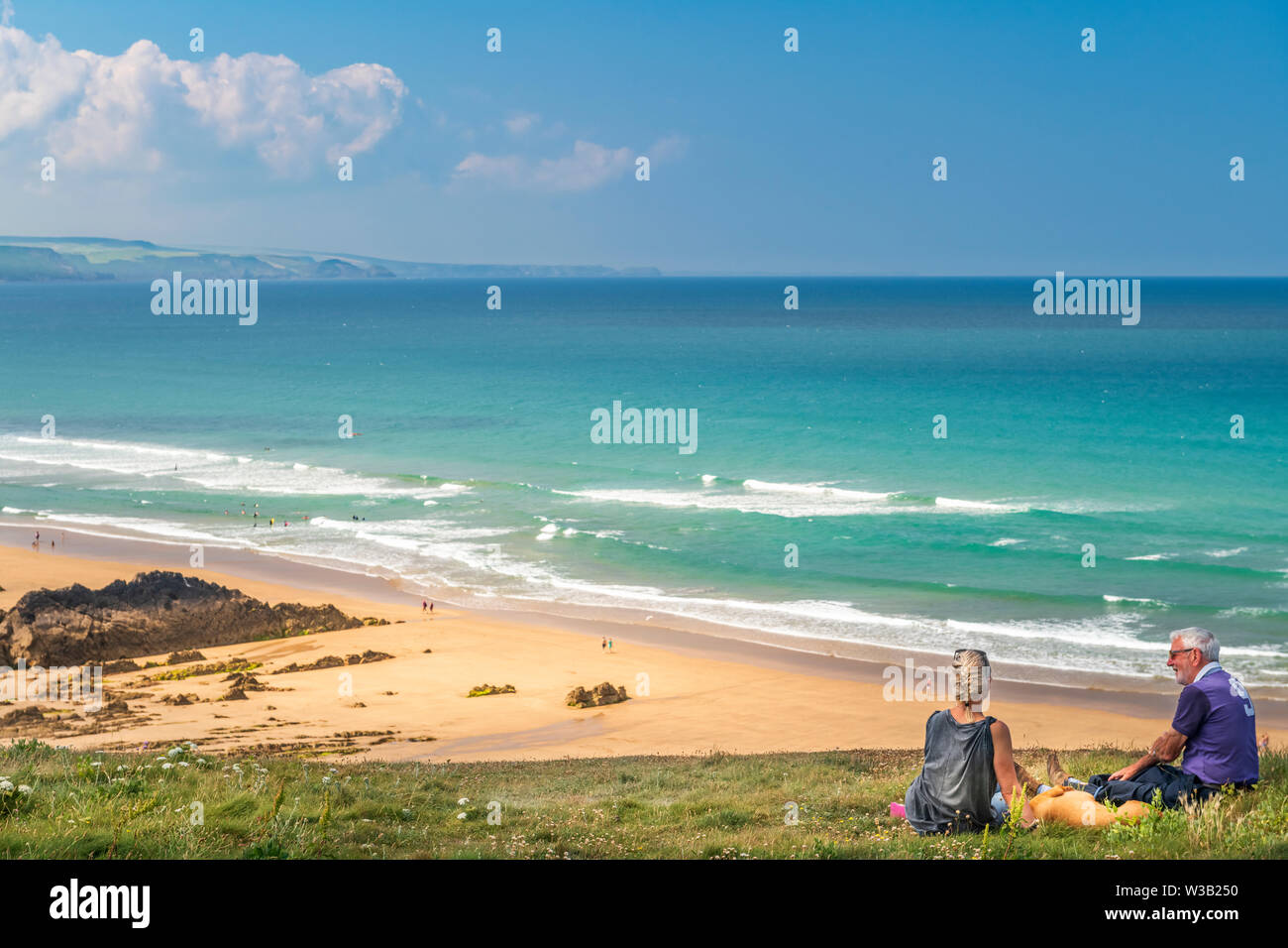 Cornwall, UK. 14th July, 2019. UK Weather. A couple enjoy the panoramic views over the North