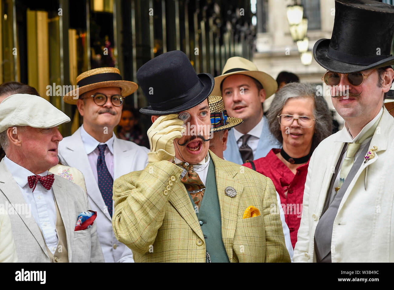 London, UK. 14 July 2019.   Elegantly dressed people take part in The Grand Flâneur walk.  Starting at the Beau Brummell statue on Jermyn Street, the walk coincides with the 20th anniversary of The Chap magazine and is defined as a walk without purpose, celebrating the art of the flâneur, oblivious to going anywhere specific, and an antidote to the demands of modern life and the digital smartphone.  Similar walks are taking place in Dusseldorf and Los Angeles. Credit: Stephen Chung / Alamy Live News Stock Photo