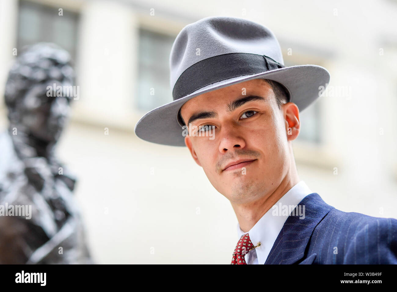 London, UK. 14 July 2019.   An elegantly dressed man takes part in The Grand Flâneur walk.  Starting at the Beau Brummell statue on Jermyn Street, the walk coincides with the 20th anniversary of The Chap magazine and is defined as a walk without purpose, celebrating the art of the flâneur, oblivious to going anywhere specific, and an antidote to the demands of modern life and the digital smartphone.  Similar walks are taking place in Dusseldorf and Los Angeles. Credit: Stephen Chung / Alamy Live News Stock Photo