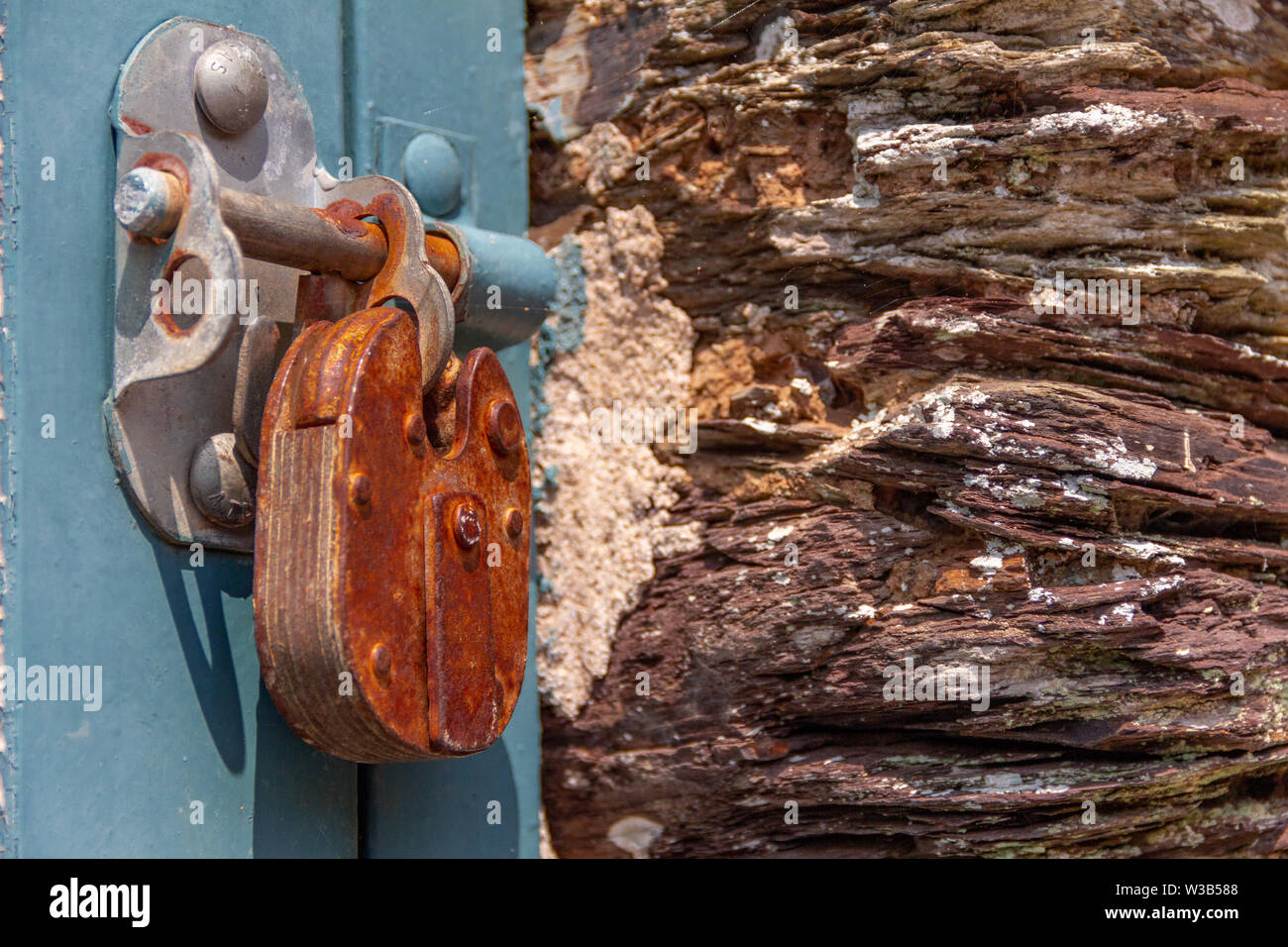 Rusty old metal lock on blue barn door Stock Photo