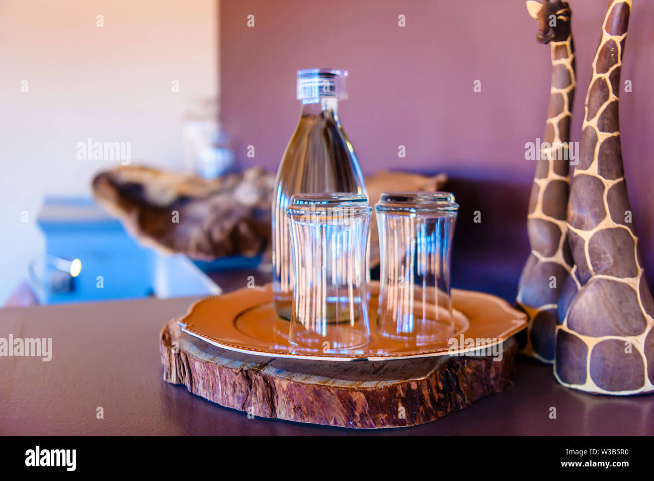 Glasses and a bottle of water in an African game lodge, Namibia Stock Photo