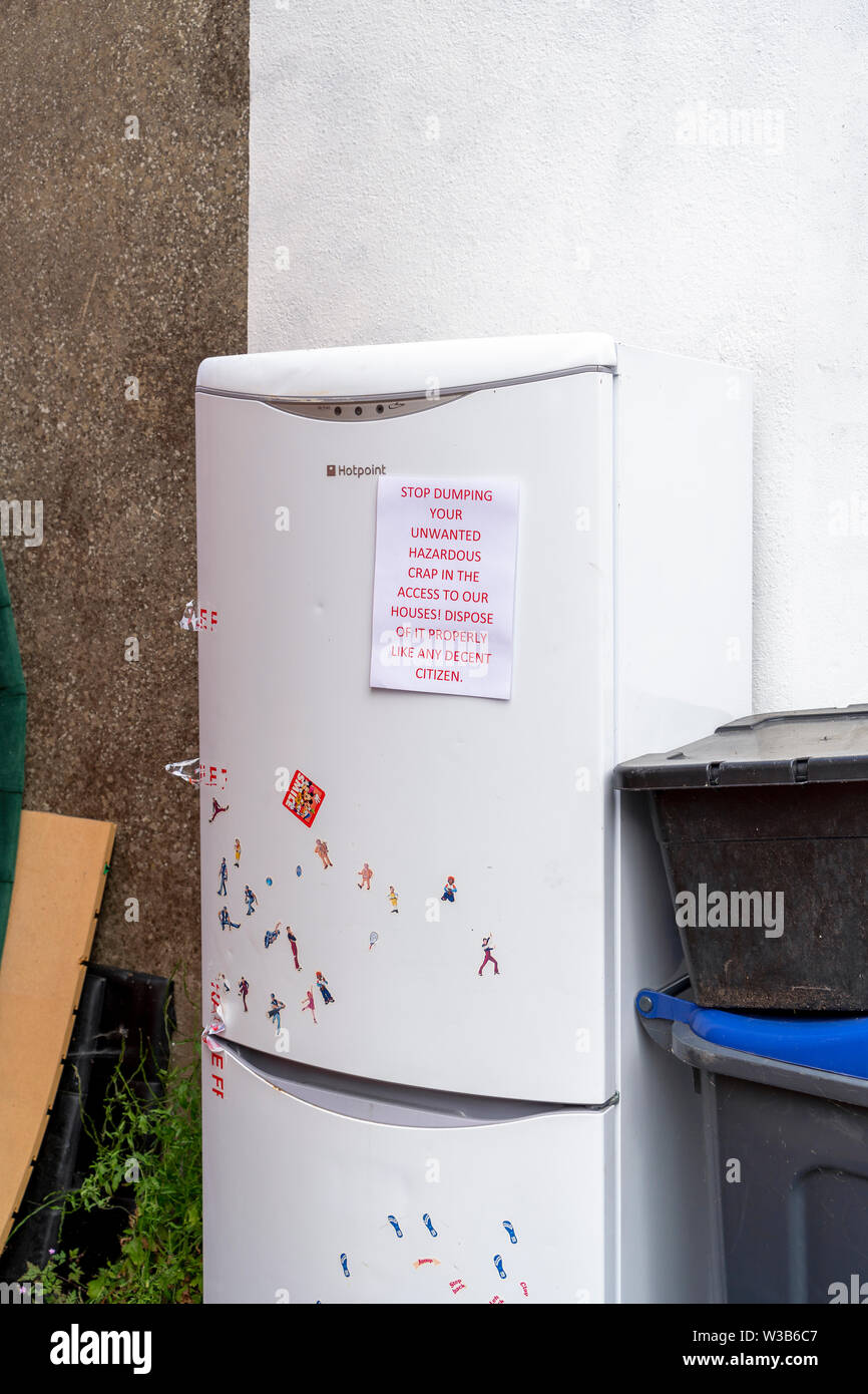 Notice left on fly tipped fridge freezer Stock Photo